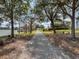Scenic community path leading to a lakeside gazebo, surrounded by lush landscaping and mature trees at 5063 Carillon Ln, Windermere, FL 34786