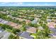 An aerial view showcases the property in a neighborhood setting, surrounded by mature trees at 5063 Carillon Ln, Windermere, FL 34786