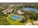 Aerial view of the tennis and basketball courts alongside the community pool and the lake at 5063 Carillon Ln, Windermere, FL 34786