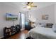 Bedroom featuring a ceiling fan, television, and comfortable bed with grey bedding and wood laminate flooring at 5063 Carillon Ln, Windermere, FL 34786