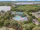 Aerial view showcases a community pool, basketball court, and tennis court near a lake and single-Gathering homes at 5063 Carillon Ln, Windermere, FL 34786