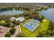 Aerial view shows the community tennis and basketball courts alongside the community pool and lake at 5063 Carillon Ln, Windermere, FL 34786