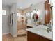 A bright bathroom featuring double sinks, wood cabinets, and a tiled walk-in shower at 5089 Jennifer Pl, Orlando, FL 32807