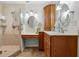 Bathroom boasts double sinks, wood cabinets and a tiled walk-in shower with glass door at 5089 Jennifer Pl, Orlando, FL 32807