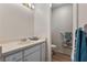 Neutral half bathroom featuring a single sink vanity and adjacent toilet area at 5089 Jennifer Pl, Orlando, FL 32807