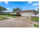 Charming single-story home with a well-manicured lawn, a two-car garage, and beautiful landscaping at 5089 Jennifer Pl, Orlando, FL 32807