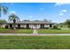 Charming single-story home featuring a well-manicured lawn and a mature palm tree in the front yard at 5089 Jennifer Pl, Orlando, FL 32807