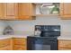 Functional kitchen with wooden cabinets, black oven and countertops, perfect for meal preparation and Gathering gatherings at 5089 Jennifer Pl, Orlando, FL 32807