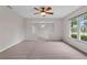 Spacious living area featuring a ceiling fan and large windows offering natural light throughout the space at 5089 Jennifer Pl, Orlando, FL 32807