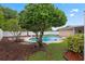 Backyard pool with mature landscaping and decorative edging around mulch at 5089 Jennifer Pl, Orlando, FL 32807