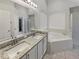 Double vanity in primary bathroom with separate tub and shower, featuring granite counters at 5231 Alavista Dr, Orlando, FL 32837