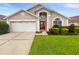 Charming single-Gathering home with red double-door entry, manicured lawn, and two car garage at 5231 Alavista Dr, Orlando, FL 32837