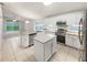 Bright, open kitchen with white cabinetry, granite countertops, stainless steel appliances, and a center island at 5231 Alavista Dr, Orlando, FL 32837