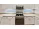 Close-up of kitchen with white cabinets, granite countertops, and stainless steel appliances, with under-cabinet lighting at 5231 Alavista Dr, Orlando, FL 32837