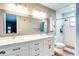 Elegant bathroom featuring a double vanity, large mirror, and a walk-in shower with classic tile at 5517 W Sacramento Ct, Orlando, FL 32821
