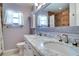 Bathroom featuring double sinks, marble countertops, and a decorative mirror at 5517 W Sacramento Ct, Orlando, FL 32821