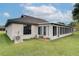 Exterior view of a home featuring a well-maintained lawn, a sunroom, and a comfortable outdoor living space at 5517 W Sacramento Ct, Orlando, FL 32821