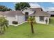 Features a well-maintained front yard with green lawn and mature palm trees at 5517 W Sacramento Ct, Orlando, FL 32821