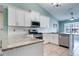 Well-equipped kitchen with granite countertops, white cabinets, and modern appliances at 5517 W Sacramento Ct, Orlando, FL 32821