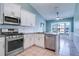Well-lit kitchen featuring stainless steel appliances, granite countertops, and ample white cabinetry at 5517 W Sacramento Ct, Orlando, FL 32821
