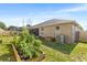 Landscaped backyard with garden boxes and grass at 610 Strihal Loop, Oakland, FL 34787