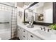 Bright bathroom with double vanity, framed mirror and updated fixtures, plus a tub and tiled shower at 610 Strihal Loop, Oakland, FL 34787
