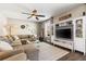 Bright living room boasts comfortable seating, a ceiling fan, and a modern entertainment center at 610 Strihal Loop, Oakland, FL 34787