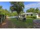 Spacious backyard with mature shade trees, fire pit, outdoor furniture and white picket fence at 63 Madera Rd, Debary, FL 32713