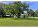 Large tree and manicured lawn surround this house, with a metal roof and hedging at 63 Madera Rd, Debary, FL 32713
