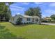 Charming single story home with metal roof, manicured front lawn, and privacy hedges at 63 Madera Rd, Debary, FL 32713