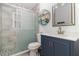 Bathroom features a sliding glass shower door, updated vanity with a white countertop and decorative wall shelf at 7058 Archwood Dr, Orlando, FL 32819