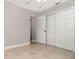 Bedroom with sliding door closet, neutral walls, and tile floors at 7058 Archwood Dr, Orlando, FL 32819