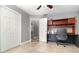 Bedroom with built-in desk and shelving, ceiling fan, and access to hallway, offering a functional workspace at 7058 Archwood Dr, Orlando, FL 32819