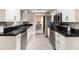 Modern kitchen featuring white cabinets, black countertops, and stainless steel appliances at 7058 Archwood Dr, Orlando, FL 32819