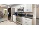 Bright kitchen with white cabinets, stainless steel appliances, and black countertops at 7058 Archwood Dr, Orlando, FL 32819