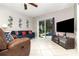 Relaxing living room with a blue sofa, entertainment center, and a view of the backyard pool at 7058 Archwood Dr, Orlando, FL 32819