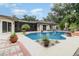 Inviting backyard pool surrounded by lush landscaping, perfect for outdoor relaxation and entertainment at 7058 Archwood Dr, Orlando, FL 32819