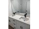 Bathroom with double vanity featuring elegant white cabinets, quartz countertop, and modern black fixtures at 706 Marion Oaks Manor, Ocala, FL 34473