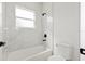 Bright bathroom with white marble tile and a black shower head over a clean, white tub at 706 Marion Oaks Manor, Ocala, FL 34473