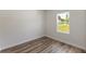 Sunlit room featuring wood-look flooring, crisp white walls, and a window with a pleasant outdoor view at 706 Marion Oaks Manor, Ocala, FL 34473