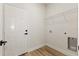 Clean laundry room with wood-look floors, white door, and convenient overhead wire shelving at 706 Marion Oaks Manor, Ocala, FL 34473