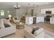 Living room flows to kitchen with white cabinetry and stainless appliances offers inviting gathering spaces at 706 Marion Oaks Manor, Ocala, FL 34473