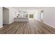 Open-concept living space with wood-look flooring and a seamless flow into the kitchen at 706 Marion Oaks Manor, Ocala, FL 34473