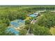 Beautiful aerial view of a tennis court, pool, and park on a lake with forest backdrop at 720 Celebration Ave # 245, Kissimmee, FL 34747