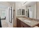 Bathroom with double sinks, granite countertop, and multiple mirrors at 720 Celebration Ave # 245, Kissimmee, FL 34747