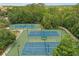 Aerial view of three tennis courts with a green surround, and a nearby park at 720 Celebration Ave # 245, Kissimmee, FL 34747