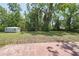 Expansive backyard with mature trees, a shed, and a concrete patio area at 881 Cedar Cir, Tavares, FL 32778