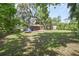 Expansive backyard with mature trees, a patio, a trampoline, and partial views of the home at 881 Cedar Cir, Tavares, FL 32778