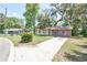 Charming single-story home with a brick facade, manicured lawn, and a paved driveway at 881 Cedar Cir, Tavares, FL 32778