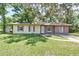 Charming single-story home featuring a well-maintained lawn and mature shade trees at 881 Cedar Cir, Tavares, FL 32778